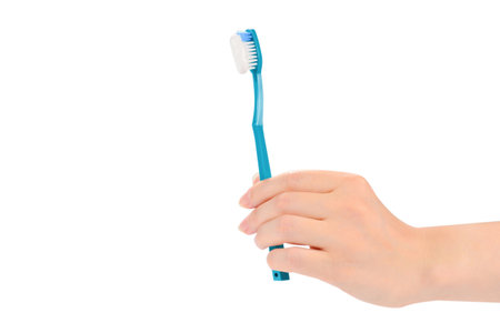 Woman holds toothbrush with toothpaste in her hand isolated on white background.の写真素材