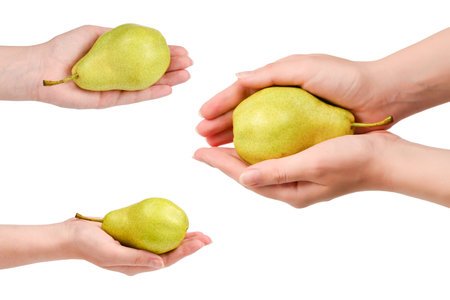 Green pear isolated on white background in woman hands.の写真素材