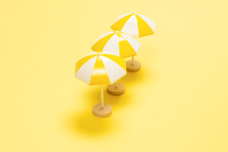 Sun lounger and yellow umbrella on a yellow background.の写真素材