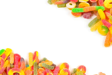 Frame of assorted gummy candies isolated on white. Top view. Space for text or design.