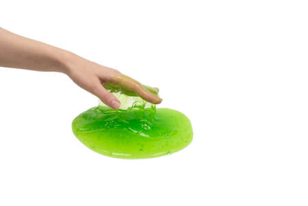 Green slime toy in woman hand isolated on white background.の写真素材