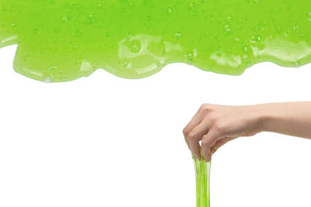 Green slime toy in woman hand isolated on white background.の写真素材