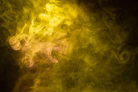 Yellow and pink steam on a black background. Copy space.の写真素材