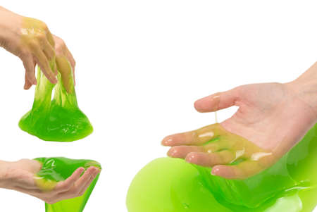 Green slime toy in woman hand isolated on white background.の写真素材