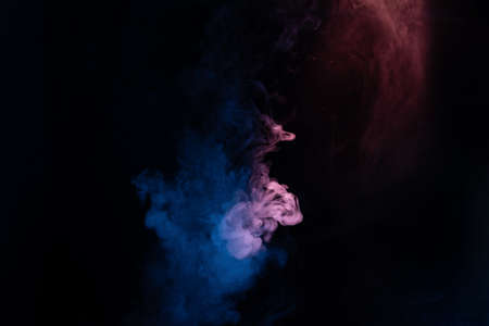 Blue and pink steam on a black background. Copy space.の写真素材
