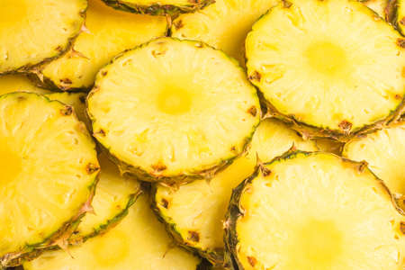 Pineapple juicy yellow slices background. Top view.の写真素材