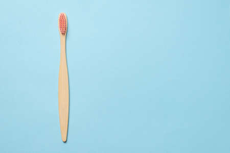 Bamboo toothbrush on a blue background. Top view.の写真素材