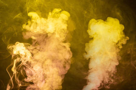 Yellow and pink steam on a black background. Copy space.の写真素材