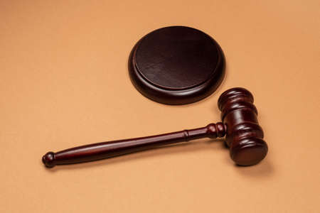 Gavel down on stand on brown background. Justice of law system conceptual. Copy space.の写真素材