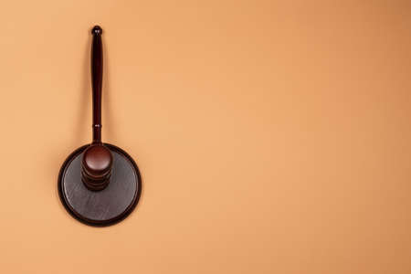 Gavel down on stand on brown background. Justice of law system conceptual. Copy space.の写真素材