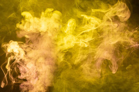 Yellow and pink steam on a black background. Copy space.の写真素材