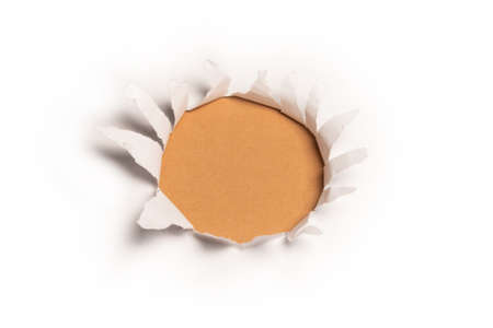 A hole in a white paper on an orange background, copy space.の写真素材