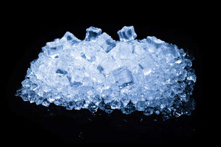 Ice crystal cubes on a black background, space for text or design.