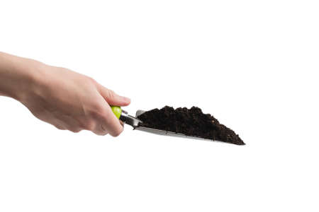 Little green shovel with soil in woman hand isolated on white background.の写真素材