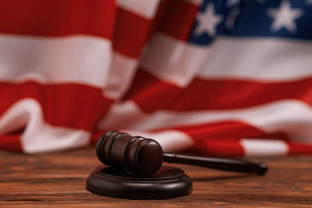 Wooden judge gavel and soundboard on american flag background. Justice of law system conceptual.