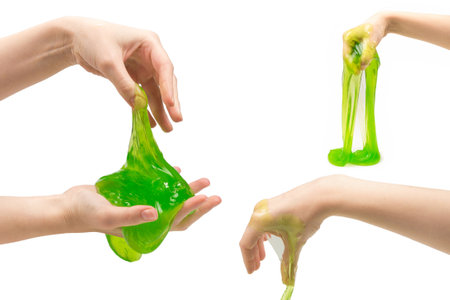 Green slime toy in woman hand isolated on white.