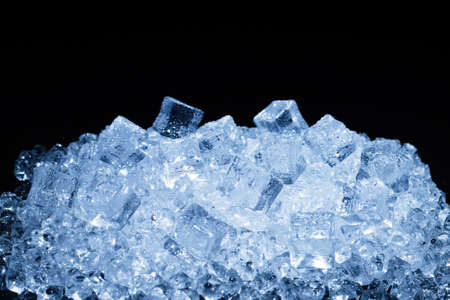Ice crystal cubes on a black background, space for text or design.