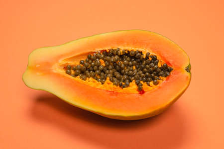 Papaya fruit on a orange background. Tropical fruit. Half papaya.の写真素材