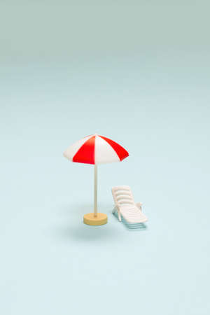 Travel concept. Sun lounger, red umbrella on a blue background. Copy space.の写真素材