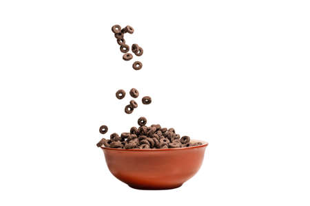 Chocolate rings cereal spill out into a bowl. Breakfast. Isolated on a white background.の写真素材