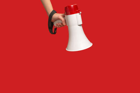 Megaphone in woman hands on a red background. Copy space.の写真素材