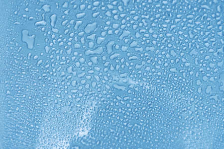 Blue glass with water drops. Wet glass. Copy space.