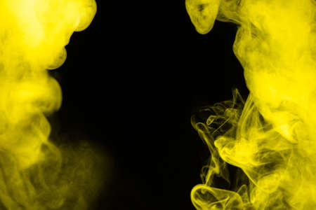 Yellow steam on a black background. Copy space.の写真素材