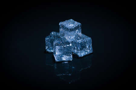 Ice crystal cubes on a black background, space for text or design.の写真素材