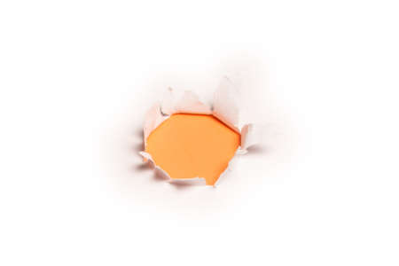 A hole in a white paper on an orange background, copy space.