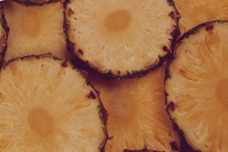 Pineapple juicy yellow slices background. Top view.