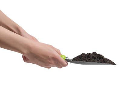Little green shovel with soil in woman hand isolated on white background.の写真素材