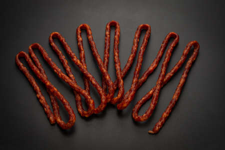 Cabanossi, dry sausage isolated on a black background.の写真素材