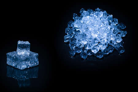 Ice crystal cubes on a black background, space for text or design.
