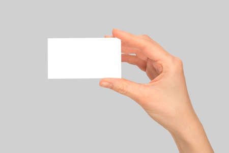 Empty card in woman hand isolated on a gray background.