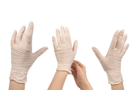 Woman puts on white rubber gloves. Isolated on white.の写真素材