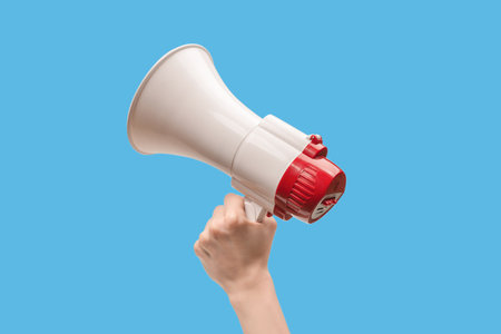 Megaphone in woman hands on a white background. copyspace.の写真素材