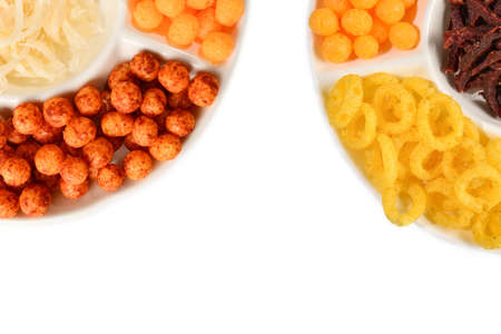 Mix of snacks on a white plate isolated on white.