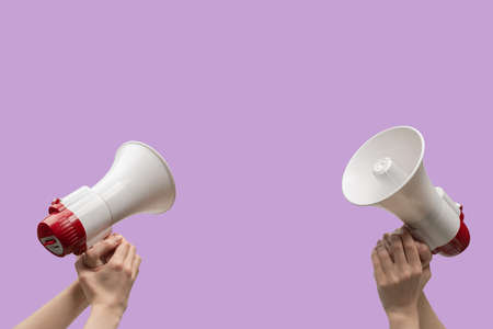 Megaphone in woman hands on a purple background. copyspace.の写真素材