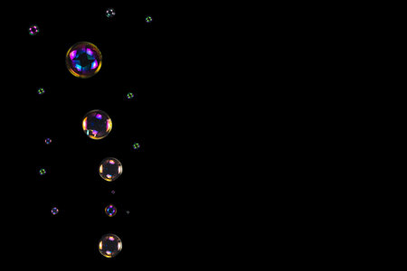 Soap bubbles isolated on a black background. Copy space.