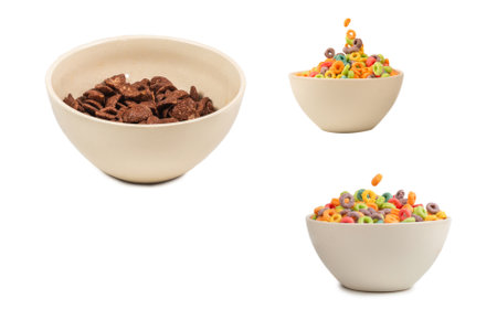 Chocolate corn flakes falling to the white bowl isolated on white. Motion. Copyspace.の写真素材