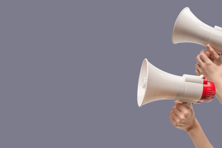 Megaphone in woman hands on a gray background. copyspace.の写真素材