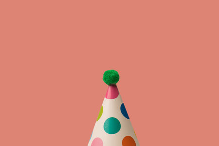 Bright and colorful birthday cap isolated on an orange background. Holiday concept.の写真素材