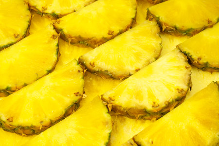 Pineapple juicy yellow slices as a background. top view.