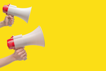 Megaphone in woman hands on a white background. copyspace.の写真素材