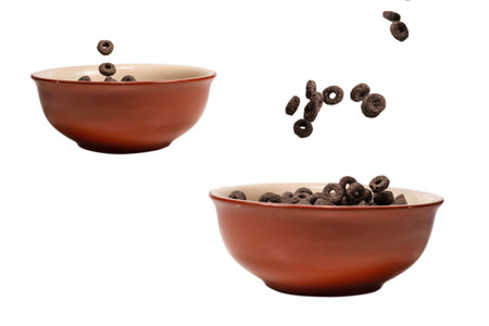 Chocolate rings cereal spill out into a bowl. Breakfast. Isolated on a white background.の写真素材