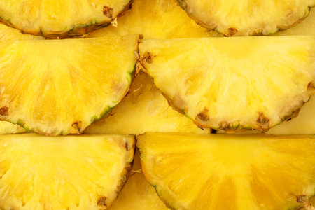 Pineapple juicy yellow slices as a background. top view.の写真素材