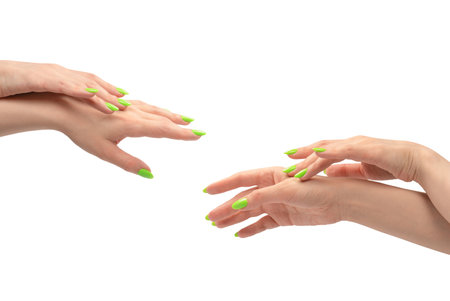 Hand of a woman with green naols hold some tiny or thin object, isolated on a white background.の写真素材