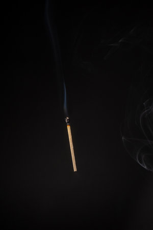 Lit and falling match on a black background.の写真素材