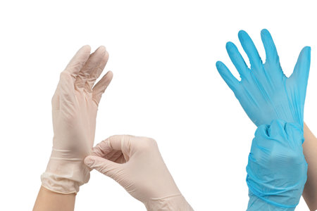 Woman puts on blue rubber gloves. Isolated on white.の写真素材