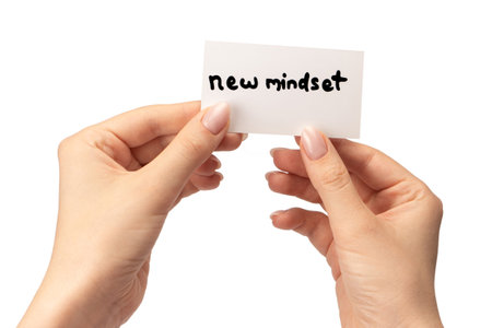 New mindset - new result text on a card in a woman hand isolated on a white background.の写真素材